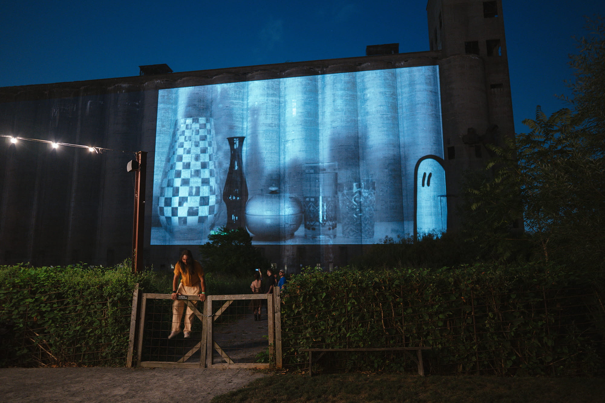 Julia Dzwonkoski ghost projection film onto Marine A grain silo man jumping fence // photo credit Pat Cray